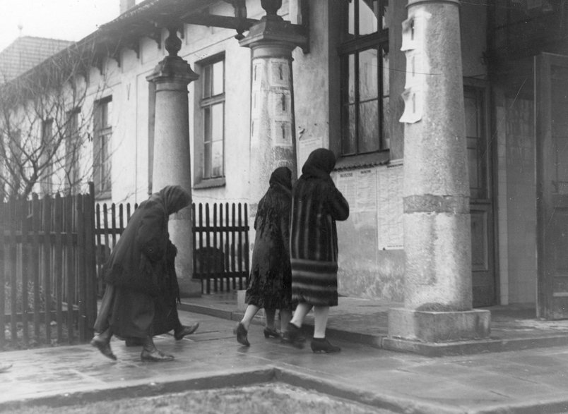Mieszkanki Płaszowa koło Krakowa w drodze do lokalu komisji wyborczej obklejonej materiałami wyborczymi BBWR, 1930 r.