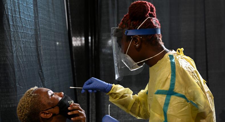 University of Maryland junior Shamar Jackson, 23, left, a Studio Arts major, is tested for the first time for covid-19 by Agnelyne Ndifor, a nursing student at Towson University.