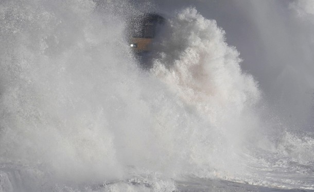 Waves hit a train during heavy seas and high winds in Dawlish in south west Britain