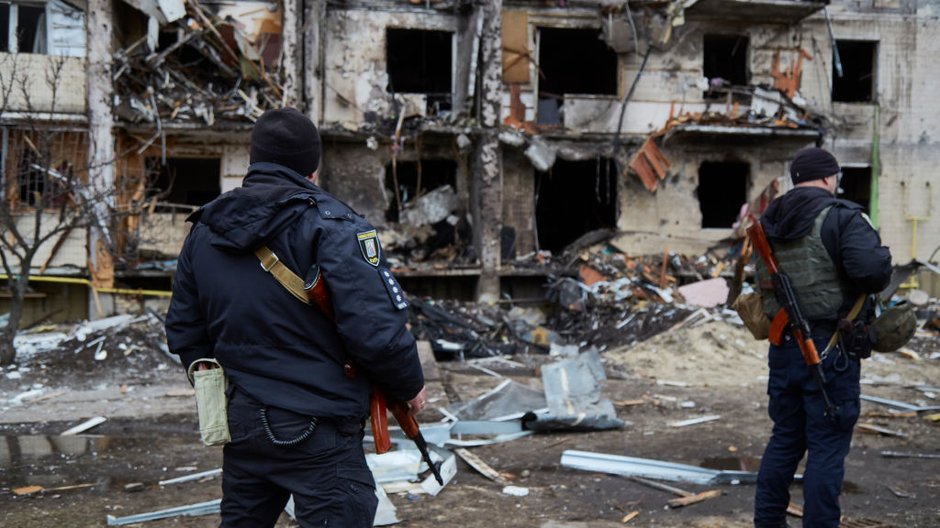 Ukraińscy policjanci przed zniszczonym budynkiem