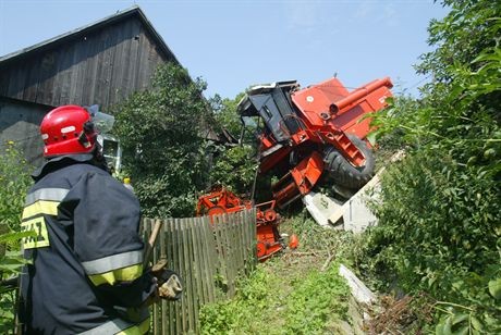 20.07.2007 Wystepa kolo Kielce (swietokrzyskie) - kombajn zjezdzal ze stromego wzniesienia, nagle wyskloczyl bieg i kombajnista nie byl juz w stanie zatrzymac maszyny. Stoczyl sie z wysokiego nasypu i uderzyl w dom.Fot. Dariusz Gacek