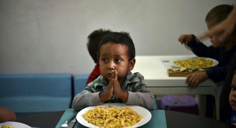 A child prays before eating at the Kapuy Foundation shelter which supports children abandoned, or with serious health problems, including undernourishment in Venezuela