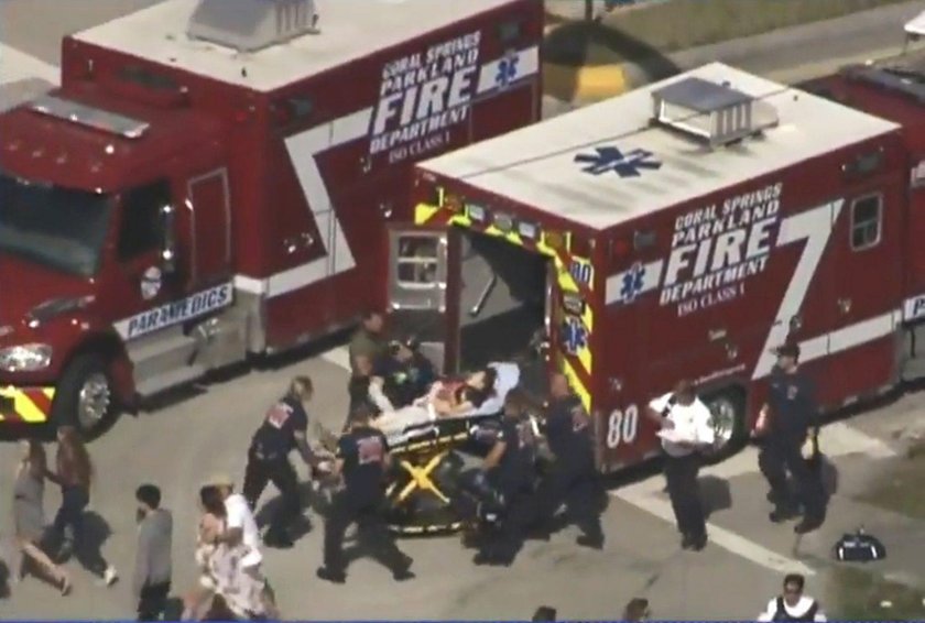 Police escort a suspect into the Broward Jail after checking him at the hospital following a shootin