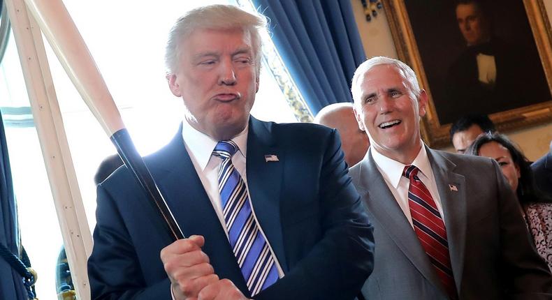 Vice President Mike Pence laughs as President Donald Trump holds a baseball bat at the Made in America product showcase event at the White House in Washington, July 17, 2017.