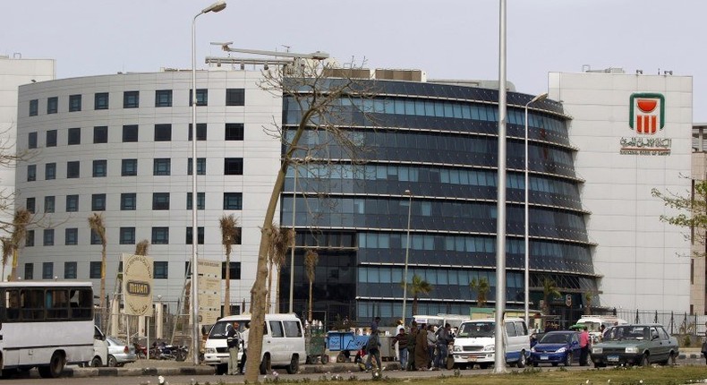 People and vehicles are seen in front of the National Bank of Egypt (NBE), also known as the Al Ahli Bank, in the Fifth Settlement districts of New Cairo March 30, 2013. REUTERS/Amr Abdallah Dalsh