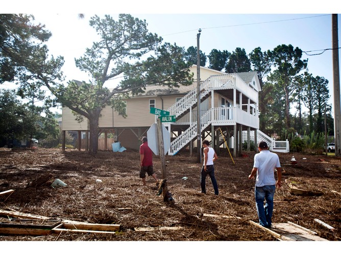 Mężczyźni idący przez miasto Outer Banks dzień po przejściu huraganu Irene. 28 sierpnia 2011