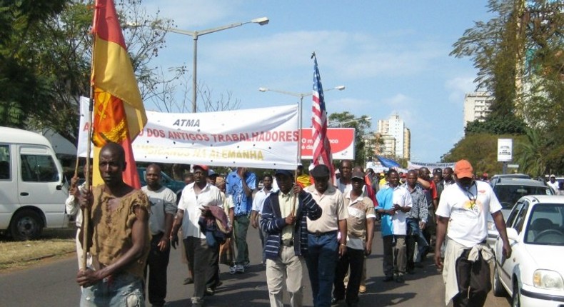 Demonstrators carrying a banner reading Association of Former Mozambican Workers in Germany march in Maputo over unpaid wages