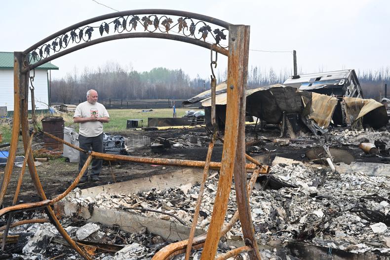 Pożary mogą wymknąć się spod kontroli i zagrozić zabudowaniom (na zdjęciu mężczyzna badający szkody w swoim domu w Drayton Valley)