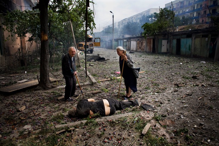 Mieszkańcy Gori patrzą na ciało ich sąsiada, który zginął podczas rosyjskiego ataku na trzy cywilne budynki, 9 sierpnia 2008