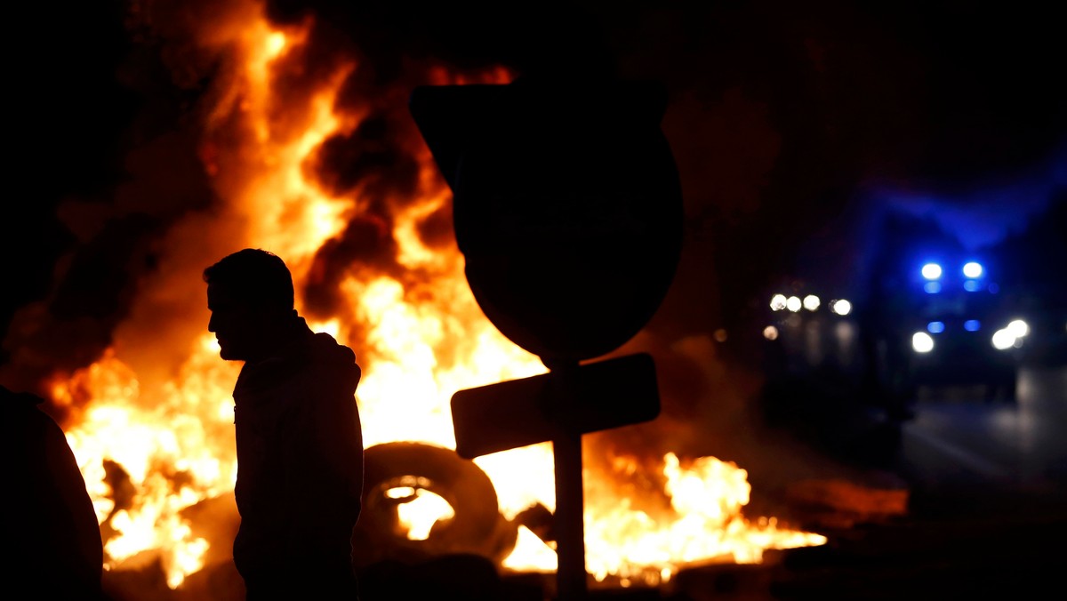 French livestock farmers gather as they burn tyres to protest falling prices near on a road in Tinteniac, western France