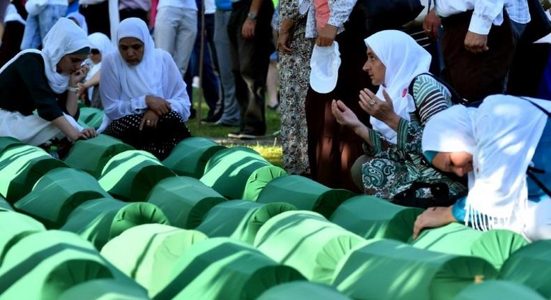 Bosnian women offers prayers near the caskets of 71 victims of the 1995 Srebrenica massacre, at the memorial cemetery in the village of Potocari on July 11, 2017