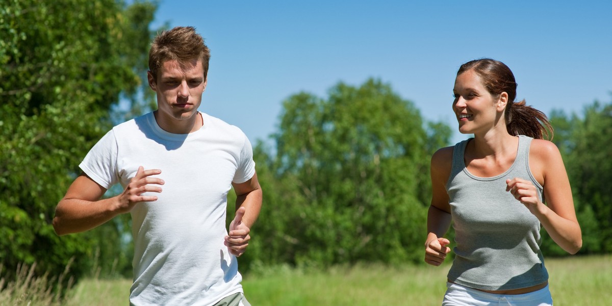 Sportive man and woman jogging outdoors