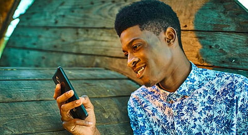 A young man scrolling through his phone