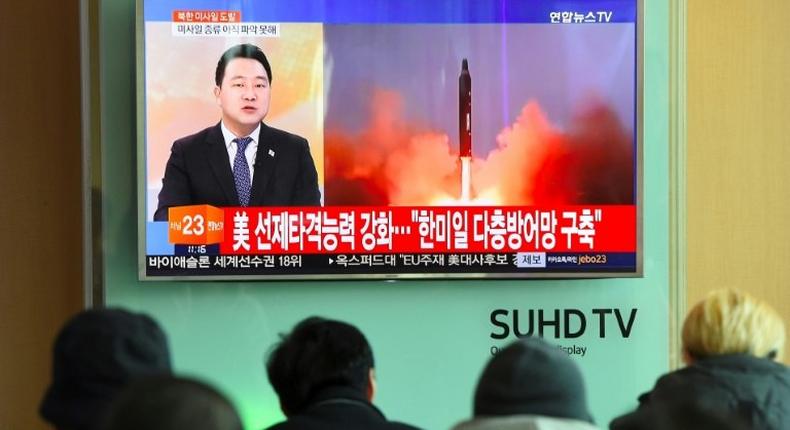 People watch the news showing file footage of a North Korean missile launch at a railway station in Seoul on February 12, 2017