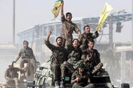 Syrian Democratic Forces (SDF) fighters ride atop of military vehicles as they celebrate victory in Raqqa