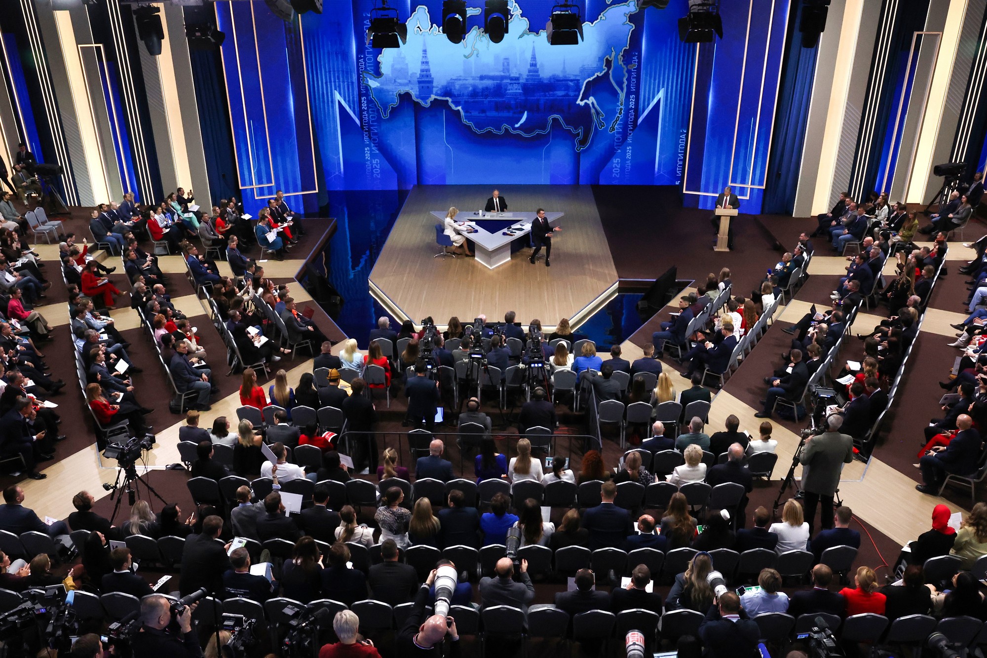 Ruský prezident Vladimir Putin (v pozadí uprostred) rozpráva počas tradičnej koncoročnej tlačovej konferencie.