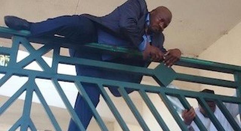 Hon Kawu Sumaila, dep minority leader of the House of Reps, climbing NASS gate to have access to the premises