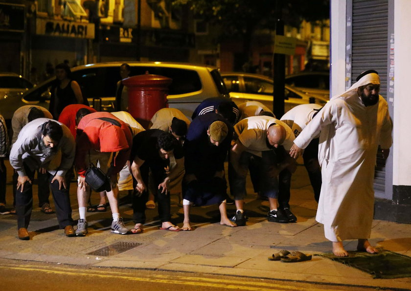 A man prays after a vehicle collided with pedestrians near a mosque in the Finsbury Park neighborhoo