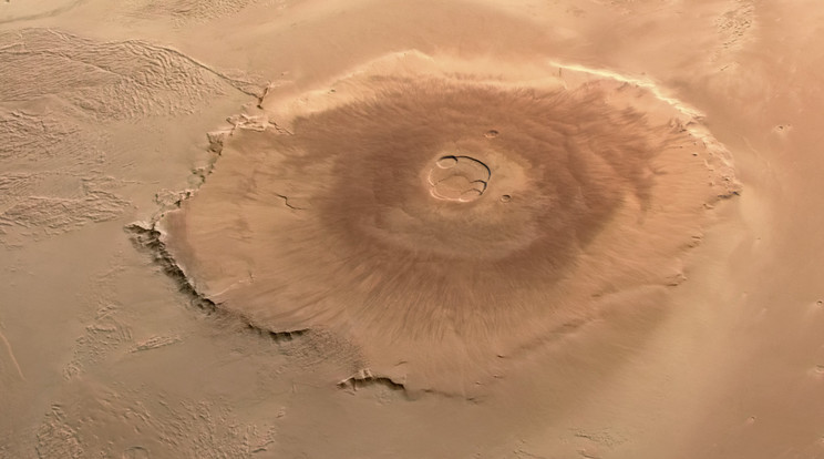 Az Olympus Mons a legnagyobb hegy a Naprendszer bolygóin. Közel háromszor olyan magas, mint a Mount Everst. De ezt a monstrumot nem tektonikus mozgások gyűrték fel, hanem a vulkánoság hozta létre, ahogyan például Hawaii-szigeteket is. Ráadásul egyre több a bizonyíték, hogy egy óriási óceán vízével körülvéve születhetett meg.  / Fotó: ESA/DLR/FUBerlin/AndreaLuck