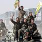 Syrian Democratic Forces (SDF) fighters ride atop of military vehicles as they celebrate victory in Raqqa