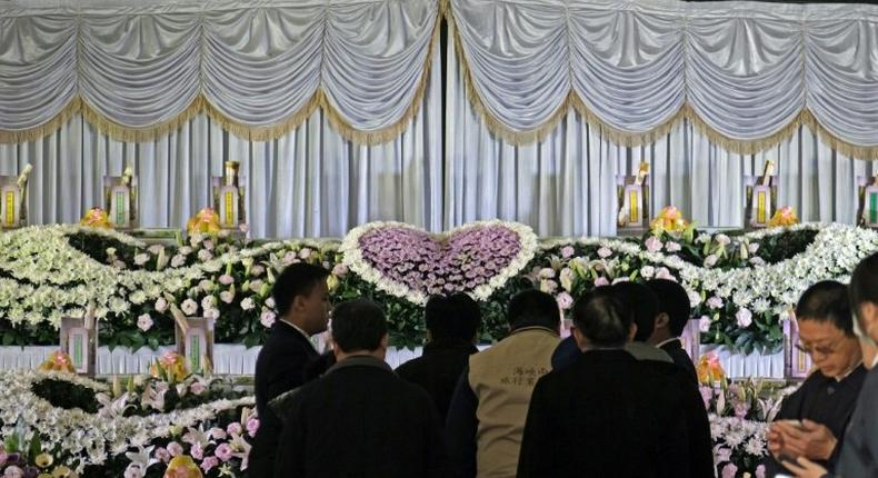 Relatives (C) mourn the victims of a bus crash in Taiwan that killed 33 local tourists