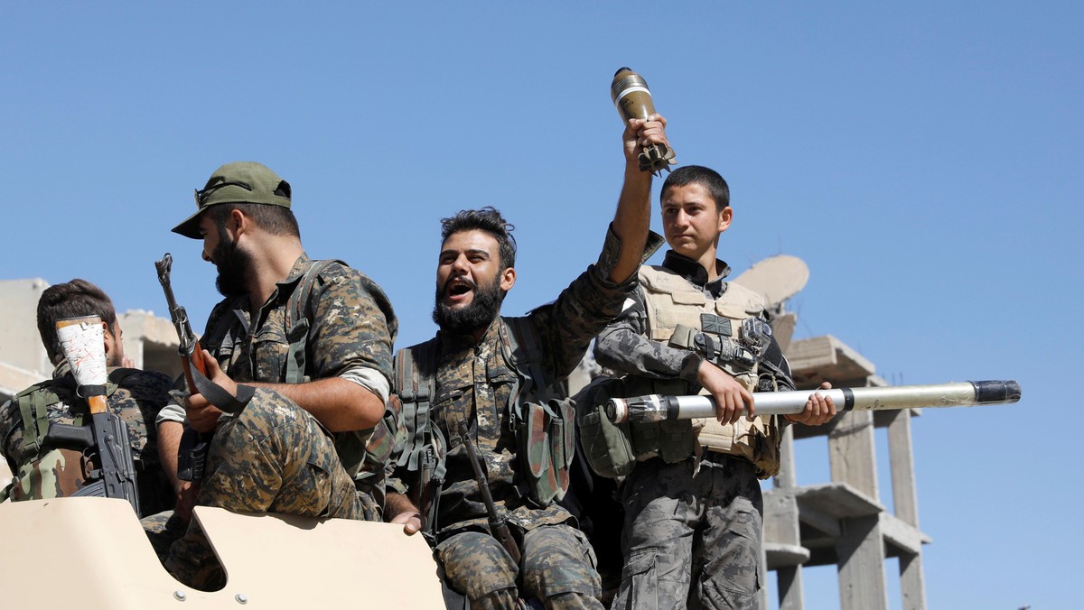 Fighters of Syrian Democratic Forces jubilate aboard an armoured fighting vehicle after Raqqa was liberated from the Islamic State militants, in Raqqa