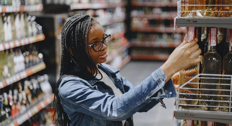 Woman shopping for wine in grocery store [Photo: Gustavo Fring]