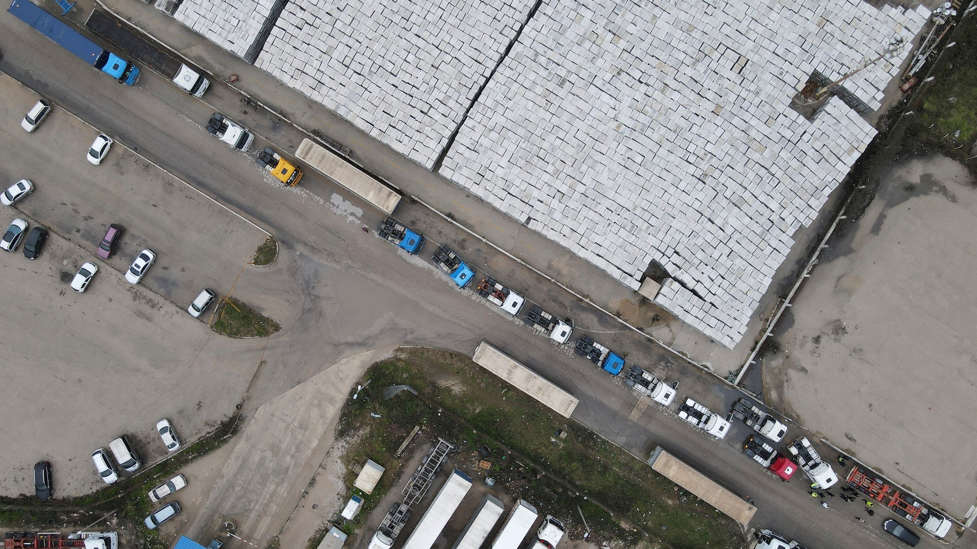 Pohľad z dronu na vodičov nákladných vozidiel a zástupcov dopravných odborov protestujúcich pred prístavom v Bari v Čiernej Hore.