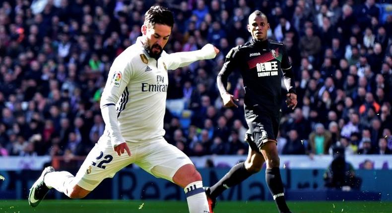 Real Madrid's midfielder Isco (L) kicks the ball to score against Granada on January 7, 2017