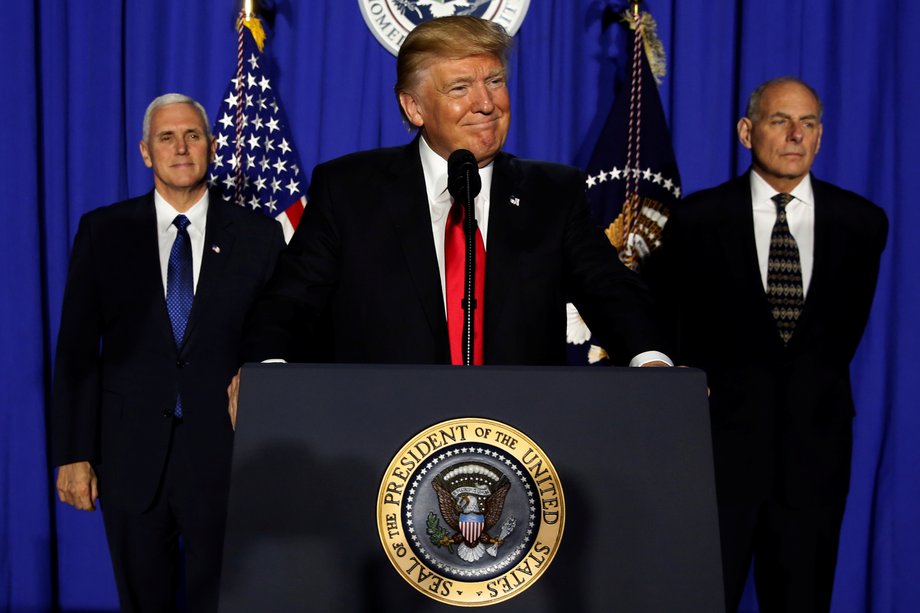 President Donald Trump (C), flanked by Vice President Mike Pence (L) and Homeland Security Secretary John Kelly (R), delivers remarks at Homeland Security headquarters on January 25, 2017.