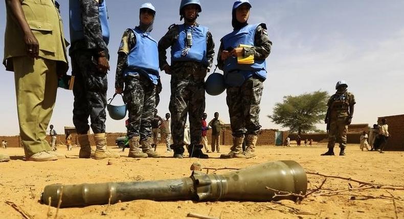 Peace keepers from the United Nations Hybrid Operation in Darfur (UNAMID) look at an RPG-7 projectile that was found at the Al-Abassi camp for internally displaced persons, after an attack by rebels, in Mellit town, North Darfur March 25, 2014. REUTERS/Mohamed Nureldin Abdallah