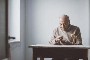 An elderly man look for some money from his wallet