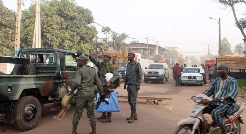 Soldiers gesture in front of La Terrasse restaurant where militants killed five people, including a French citizen and a Belgian citizen, in a gun attack in Bamako March 7, 2015.   REUTERS/Adama Diarra