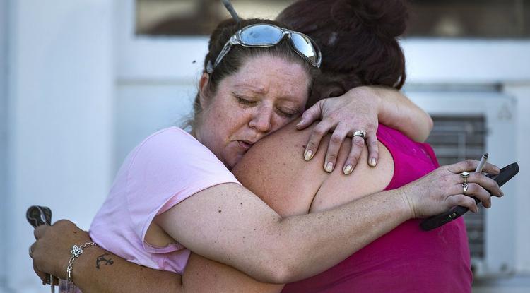 Két nő megöleli egymást a dél-texasi Sutherland Springs település baptista templománál.