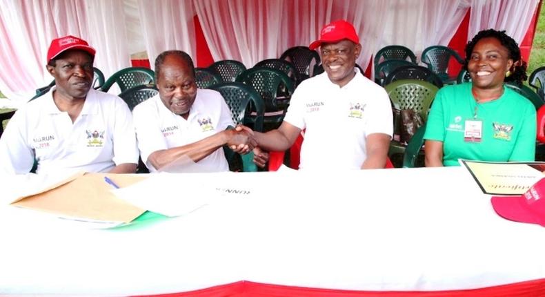 Dr. Martin Aliker (2nd L) shakes hands with the Vice Chancellor, Prof. Barnabas Nawangwe (2nd R) at the successful conclusion of the Second Edition of the Makerere University Endowment Fund (MakEF) Run (MakRun) on Sunday, March 25, 2018 as Prof. William Bazeyo (L) and Dr. Florence Nakayiwa (R) witness.