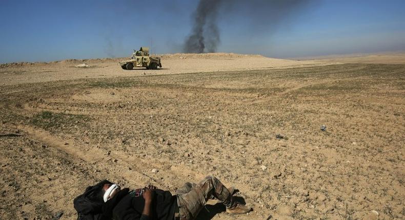 An Iraqi soldier waits to be evacuated, after he was wounded in an explosives-laden vehicle attack claimed by the Islamic State group near Mosul on February 20, 2017