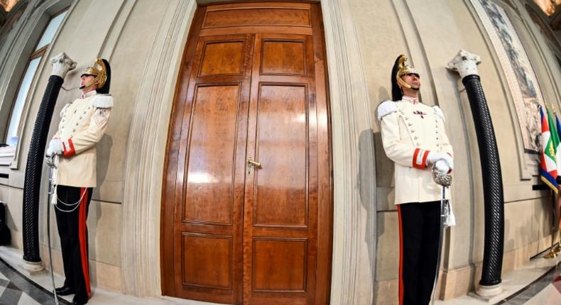 Italian elite military presidential officers stand guard outside the Quirinal palace in Rome as President Sergio Mattarella holds consultations