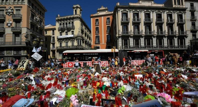 People display flowers and candles to pay tribute to the victims of the Barcelona and Cambrils attacks on the Rambla boulevard in Barcelona on August 22, 2017, five days after the attacks that killed 15 people.