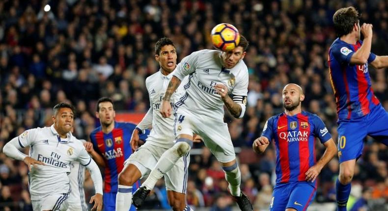 Real Madrid's Sergio Ramos (C) heads a ball to score the equalizer during the match against Barcelona at the Camp Nou stadium