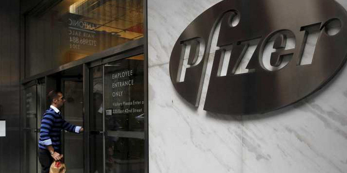 A man enters the employee entrance of the Pfizer World Headquarters building in New York