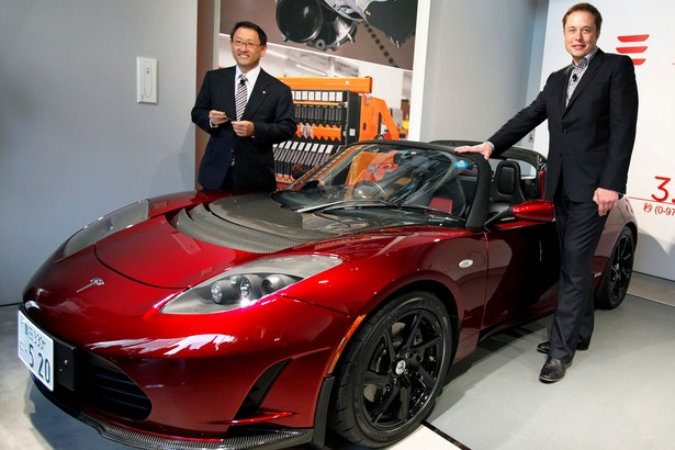 Akio Toyoda, szef Toyota Motor Corp. z lewej oraz Elon Musk, prezes Tesla Motors, przy nnowym samochodzie Tesla Roadster.