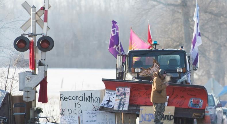 A First Nations protester walk in front of a snow plow blade that has signatures from the  Wetʼsuwetʼen hereditary chiefs as part of a train blockade in Tyendinaga, near Belleville, Ontario, Canada on February 21, 2020