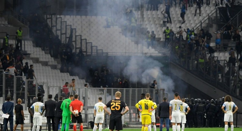 Flare for trouble: Players stand on the pitch as the match between Marseille and Galatasaray as held up Creator: NICOLAS TUCAT