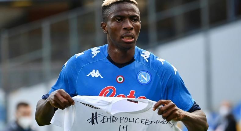 Napoli forward Victor Osimhen holds up a t-shirt 'End police brutality in Nigeria'.