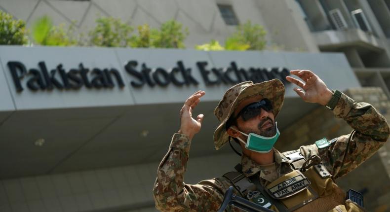 A paramilitary soldier gestures while standing guard outside the Pakistan Stock Exchange  after gunmen attacked the building