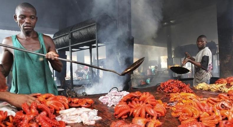 Tanzanian traders deep-fry freshly caught octopus near the shores of the commercial capital Dar es Salaam, May 4, 2010. REUTERS/Thomas Mukoya