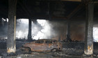 A burnt car is seen inside a gutted footwear factory in Valenzuela