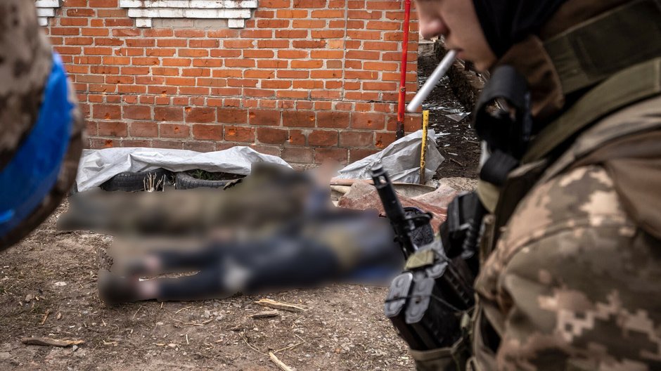 Niedaleko Charkowa. Ukraiński żołnierz przechodzi obok martwych żołnierzy rosyjskich