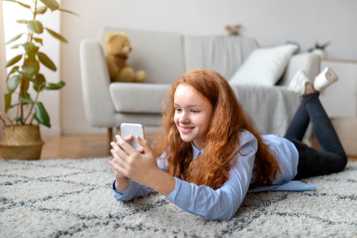 Digital,Natives.,Portrait,Of,Cheerful,Red-haired,Teen,Girl,Using,Her