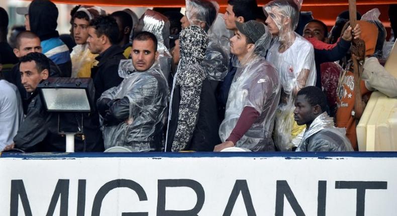 Migrants and refugees look on as they are on board of the Topaz Responder, a rescue ship run by Maltese NGO MOAS during its arrival at the Brindisi's harbour on October 27, 2016